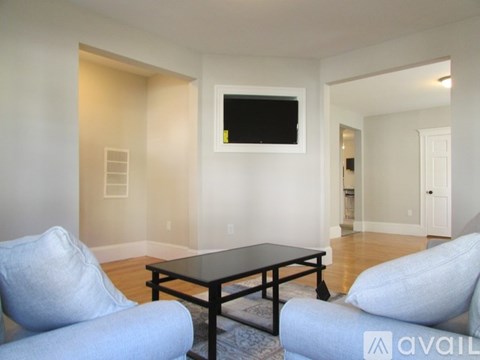 A living room with a black table and two grey chairs.