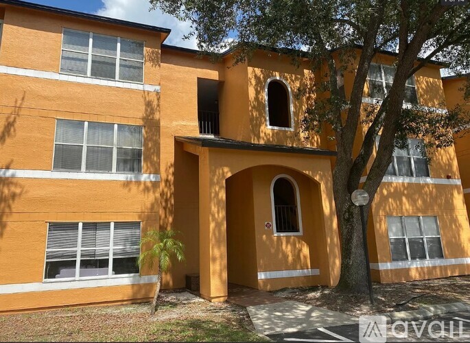 A building with orange walls and a tree in front.