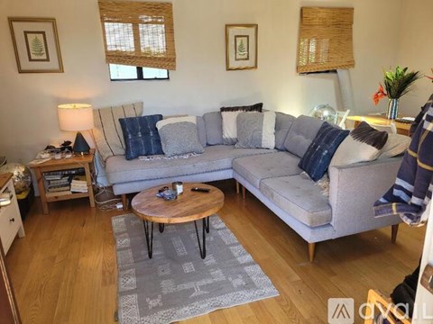 A living room with a grey couch and a wooden coffee table.
