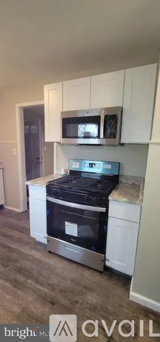 A kitchen with a stove top oven and microwave above it.