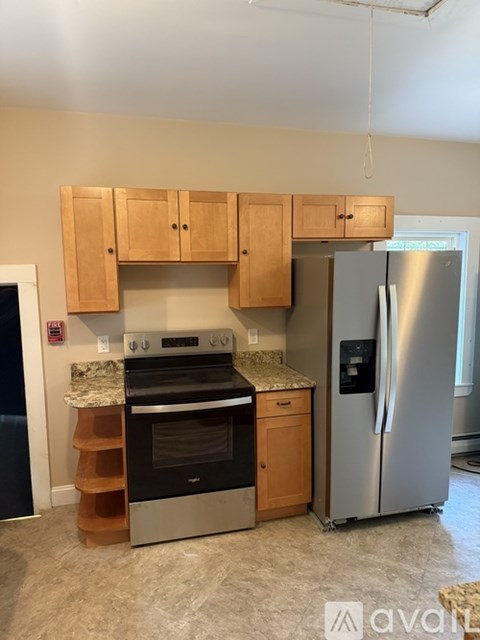 A kitchen with a stove top oven and a refrigerator.