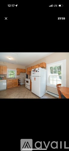 A kitchen with a white fridge and wooden cabinets.