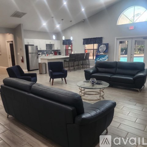A living room with black leather furniture and a pool table.