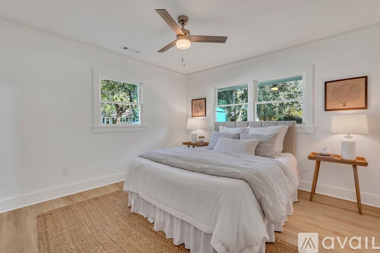 A bedroom with a large bed and a ceiling fan.