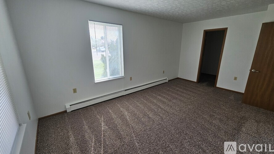 A room with a carpeted floor and a window.
