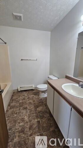 A bathroom with a toilet, sink, and a towel rack.