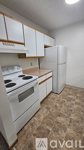 A kitchen with white appliances and brown cabinets.