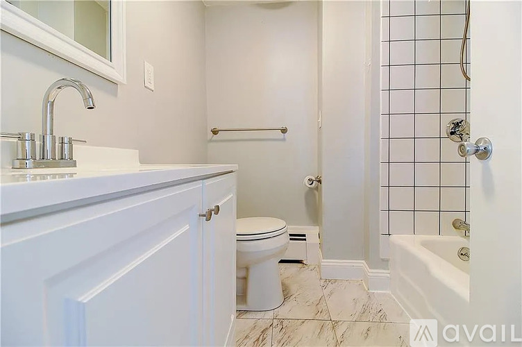 A white bathroom with a toilet, sink, and bathtub.