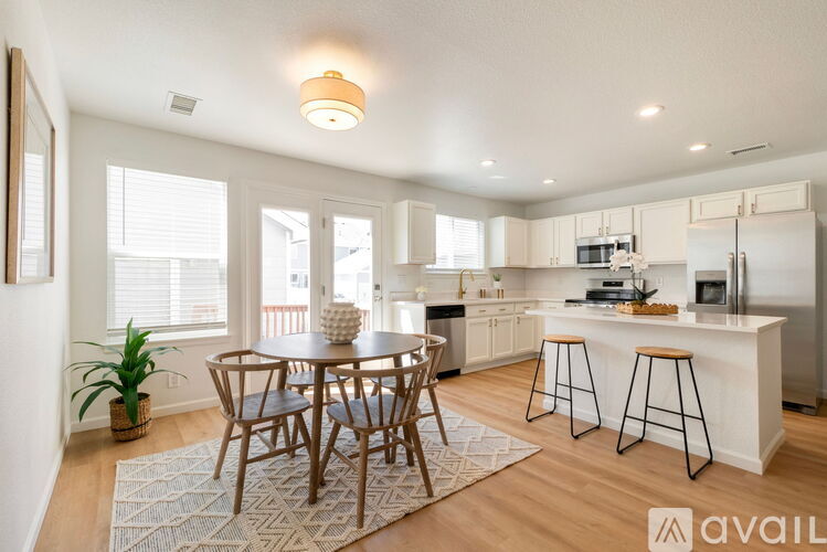 A kitchen with a dining table and chairs in the middle of the room.