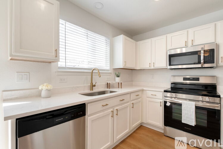 A kitchen with white cabinets and appliances.