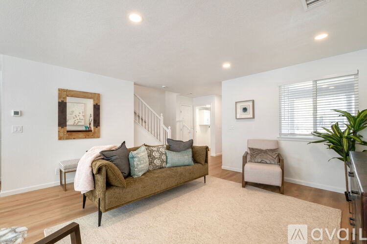 A living room with a couch, chair, and a painting on the wall.