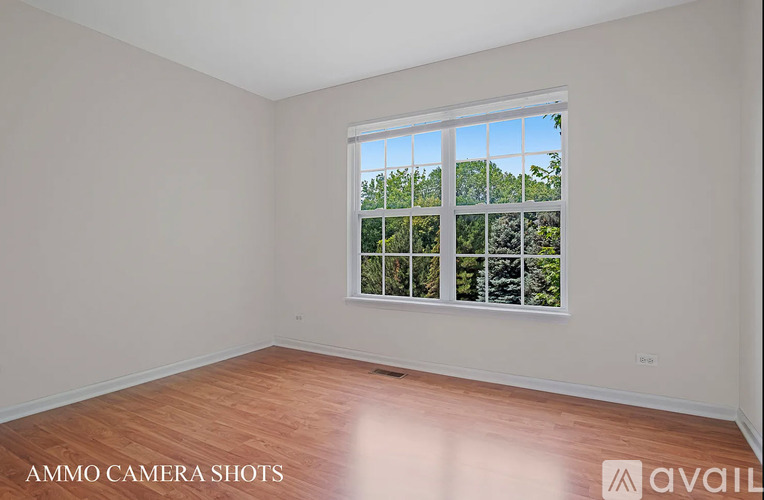 A room with a large window showing a view of trees and sky.