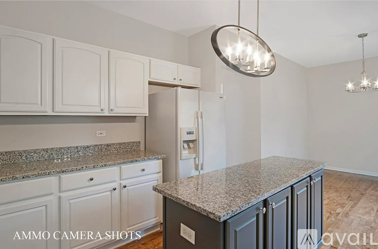 A kitchen with white cabinets and a granite countertop.