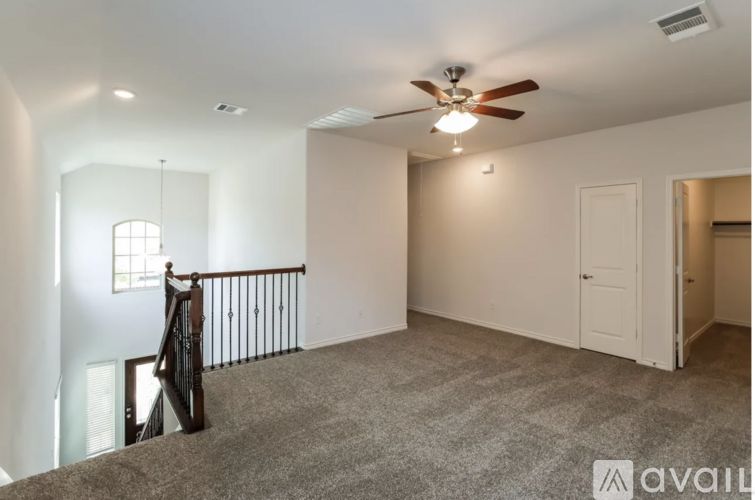 A spacious room with a ceiling fan and carpeted floor.