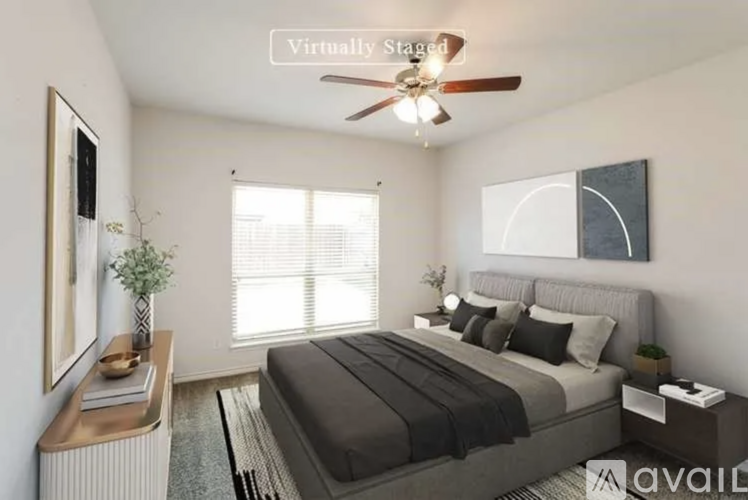 A bedroom with a large bed and a ceiling fan.