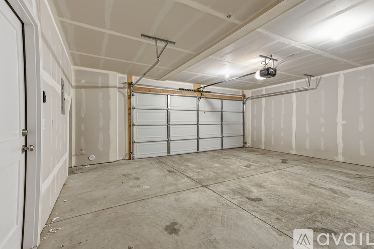 A spacious garage with a closed white door and a ceiling fan.