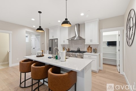A modern kitchen with a large island and pendant lights.
