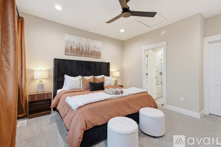 A bedroom with a large bed and a ceiling fan.