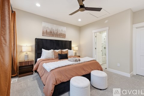 A bedroom with a large bed and a ceiling fan.