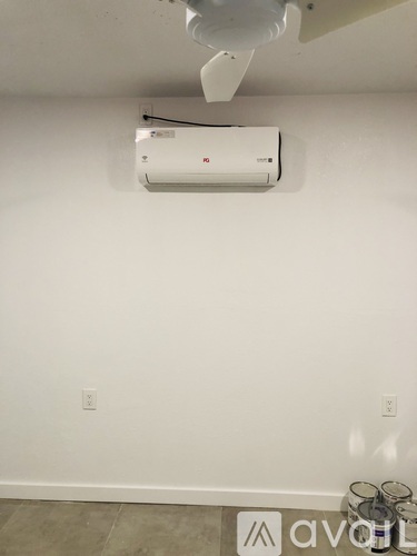 A wall-mounted air conditioner unit is installed on a white wall.