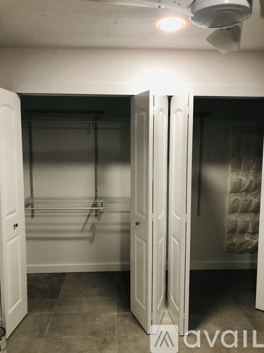 A white pantry with a white door open.