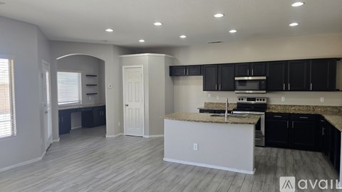 A kitchen with a white island and black cabinets is available for rent.