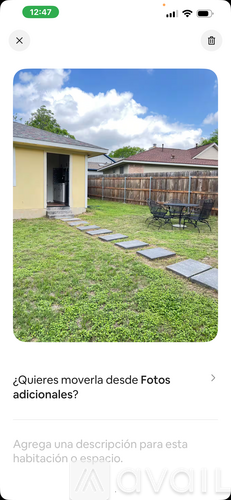 A backyard with a wooden fence and a small building.