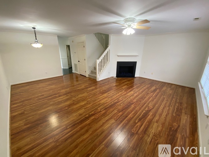 A room with wooden flooring and a staircase.