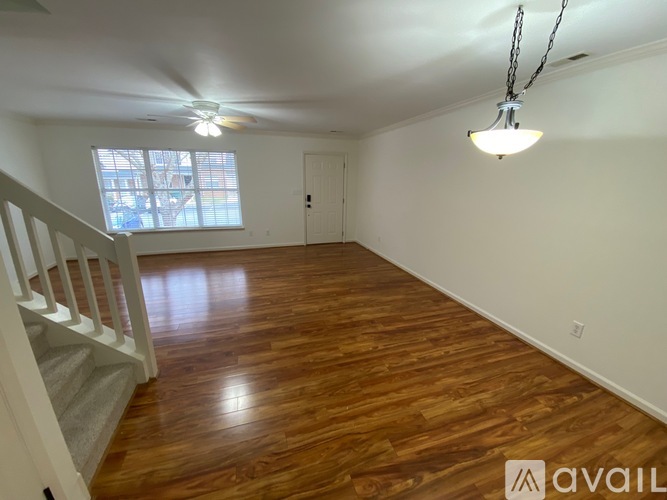 A room with wooden floors and a ceiling fan.