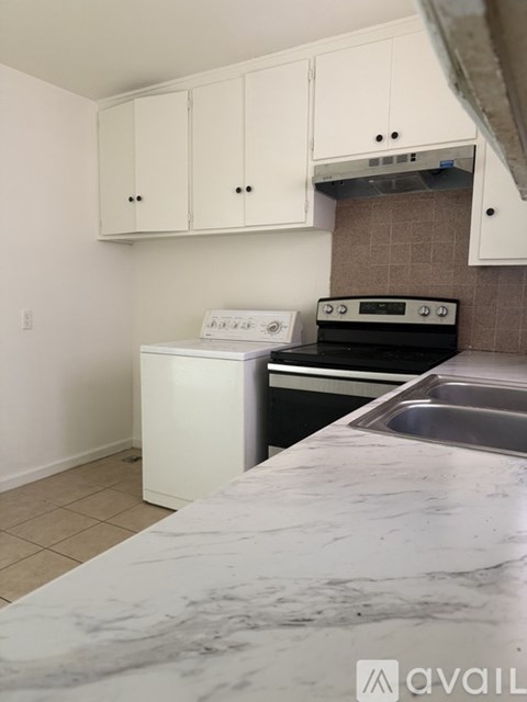 A kitchen with a white dishwasher and stove top oven.