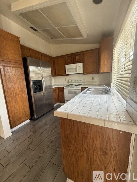 A kitchen with wooden cabinets and a white countertop.