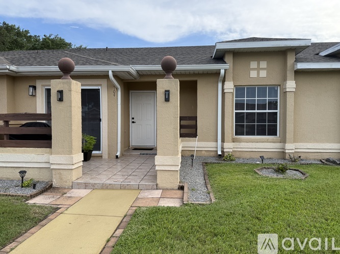 A house with a front yard and a walkway leading to the front door.