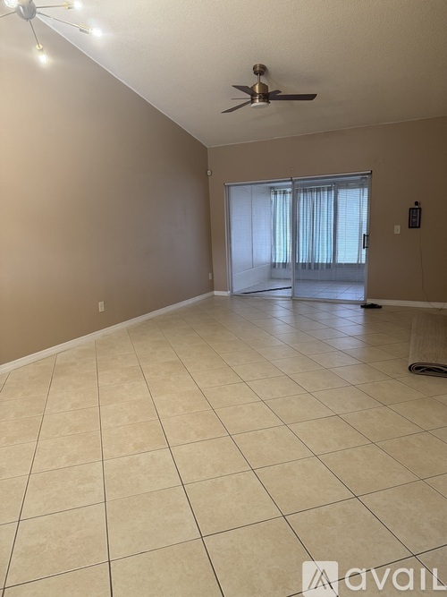 A living room with a table, chairs, and a ceiling fan.