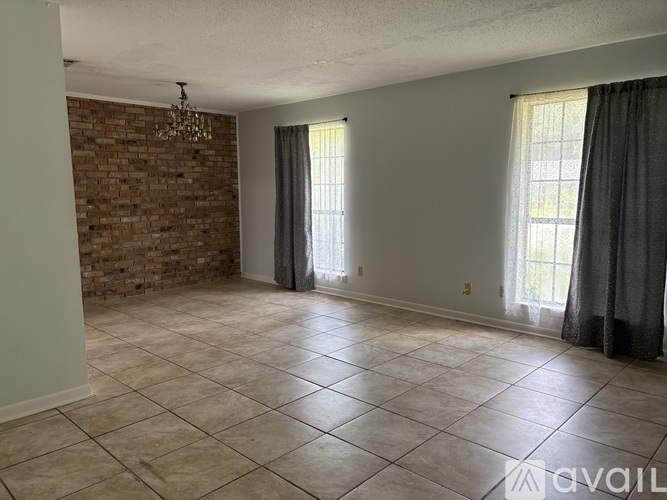 A room with a brick wall and tile flooring.