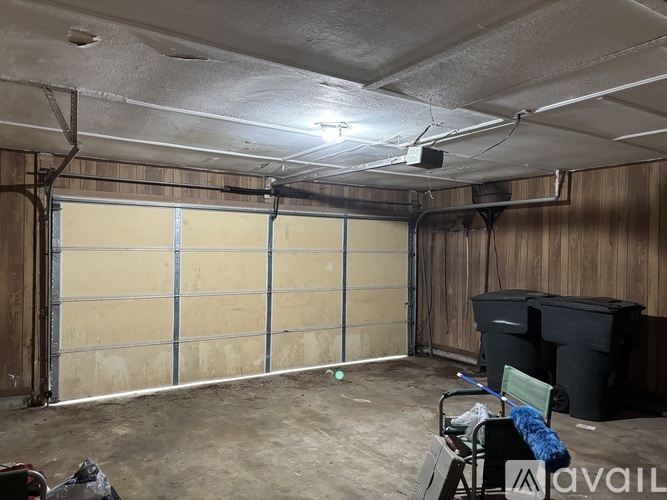 A spacious garage with a closed door and a chair in the corner.