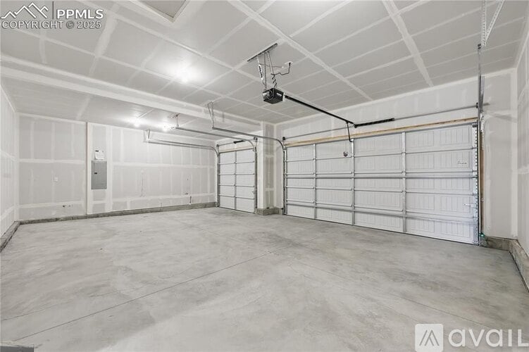 A spacious garage with a concrete floor and white walls.