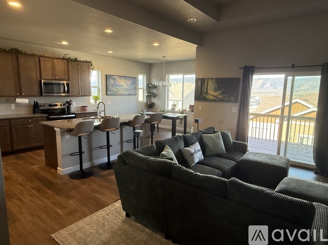 A living room with a couch and a kitchen area in the background.