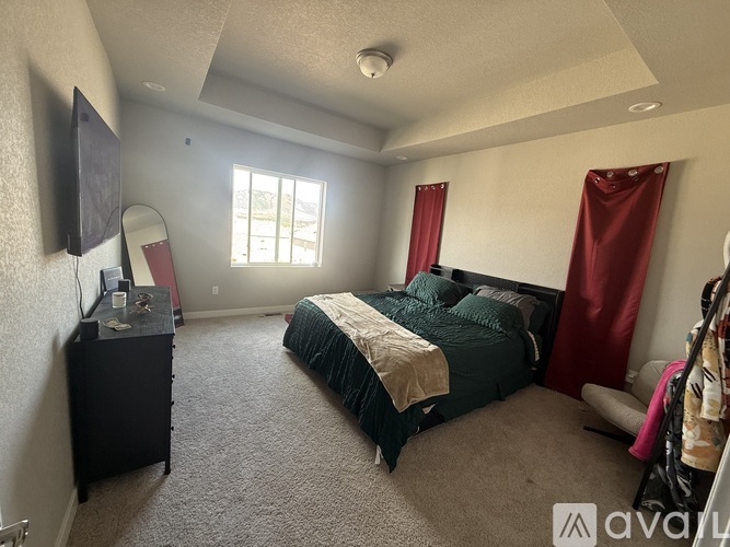 A bedroom with a bed, dresser, and mirror.