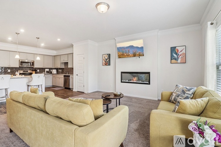 A living room with a yellow couch and a fireplace.