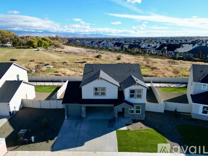 A bird's eye view of a residential area with houses and a car parked in the driveway.