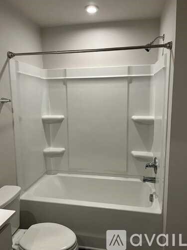 A white bathroom with a toilet and a bathtub.