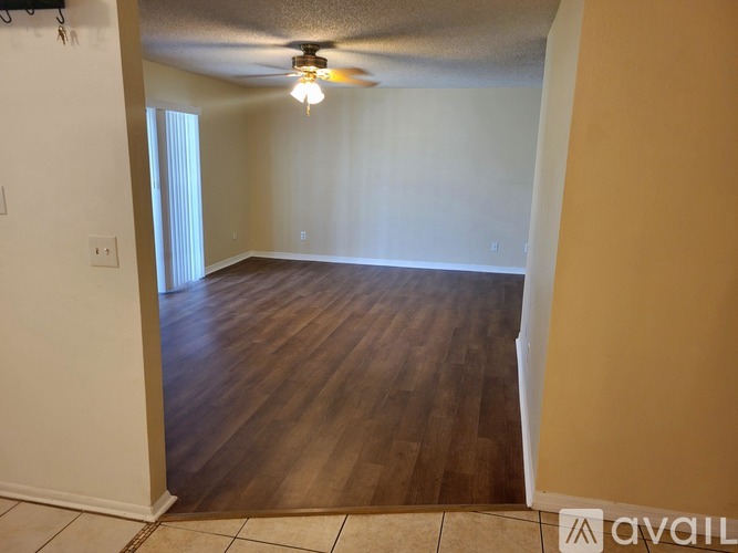 A room with wooden flooring and a ceiling fan.