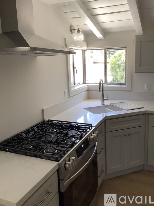 A kitchen with a stove top oven and a window.