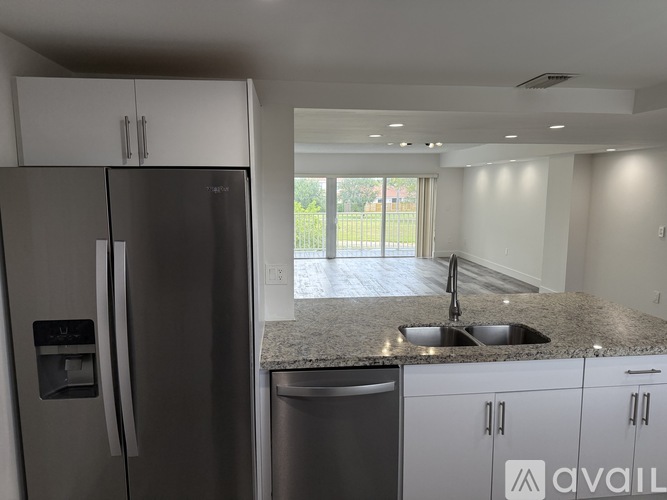 A kitchen with a granite countertop and stainless steel appliances is available for rent.