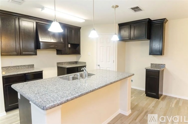 A kitchen with a granite countertop and black cabinets.