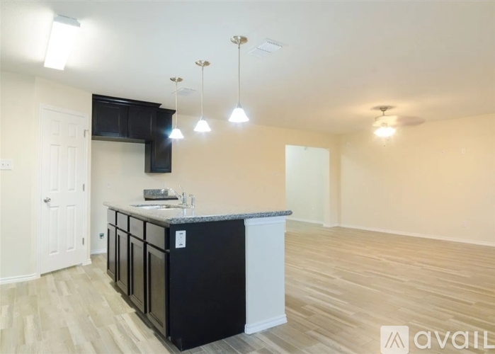 A kitchen with a black countertop and white cabinets is available for rent.