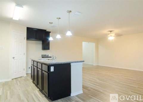 A kitchen with a black countertop and white cabinets is available for rent.