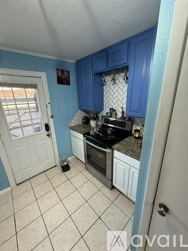 A kitchen with blue cabinets and a black stove top oven.