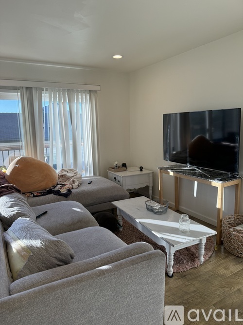 A living room with a grey couch and a white coffee table.