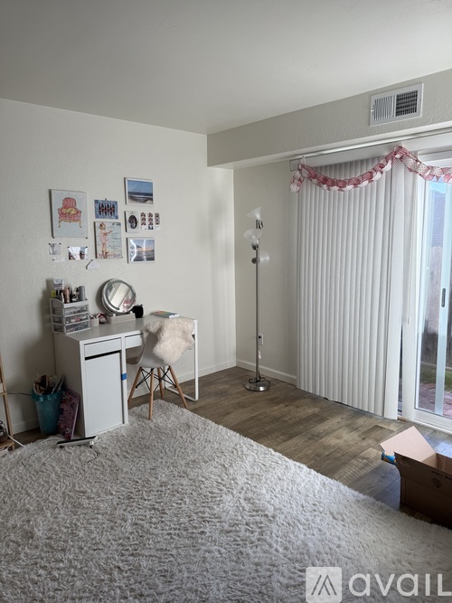 A room with a bed, desk, chair, and pictures on the wall.